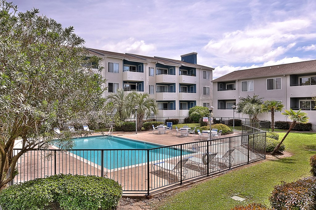 A black iron fence surrounds a small pool.