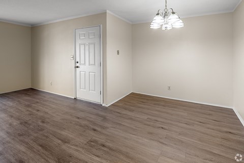 A room with a white door and a chandelier hanging from the ceiling.