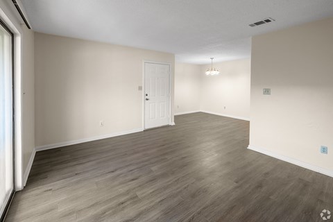 A room with wooden flooring and a white door.