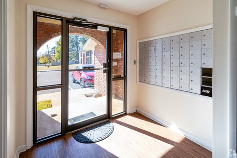 A modern house entrance with a glass door and a mailbox on the wall.