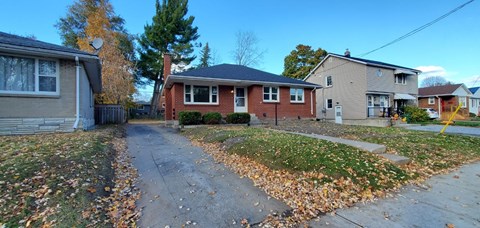 A residential area with houses and a sidewalk.