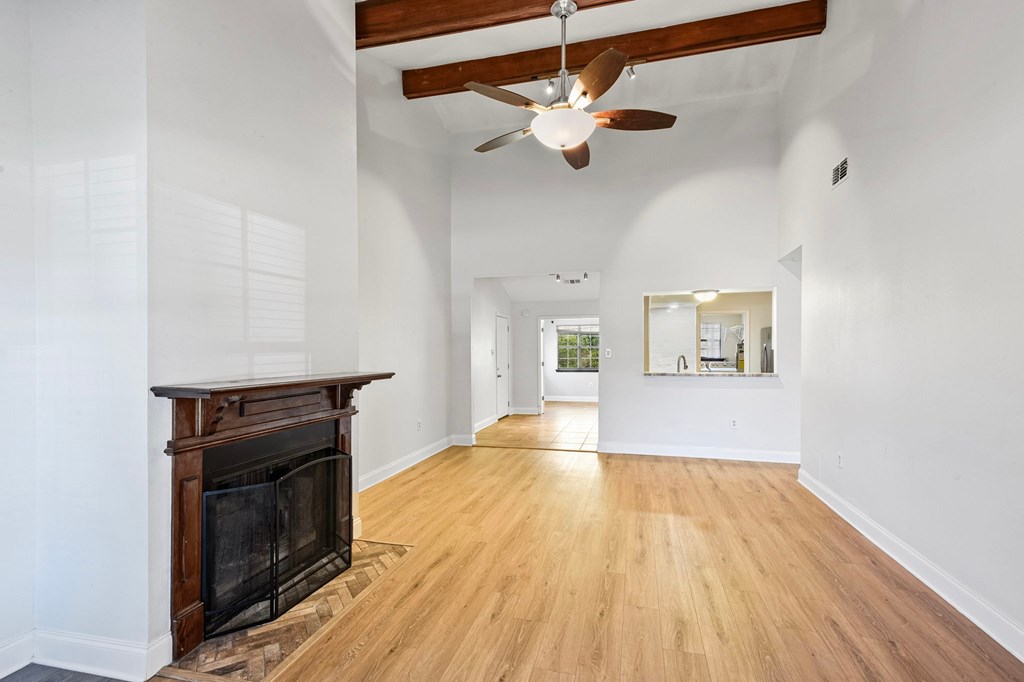 A spacious room with a fireplace and a ceiling fan.