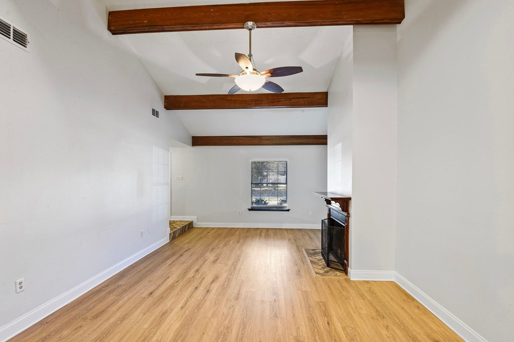 A room with wooden floors and a ceiling fan.