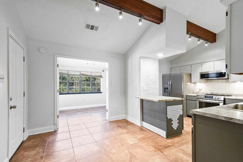 A kitchen with a sink, stove, and refrigerator.