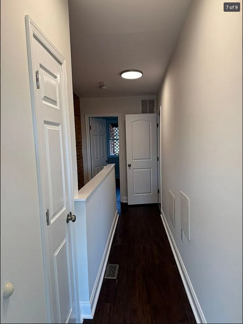 a hallway with white walls and a white door