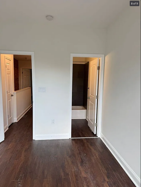 an empty living room with wood floors and white walls