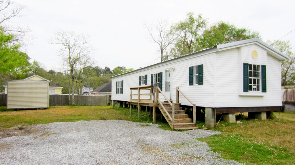 A white house with green shutters and a porch.