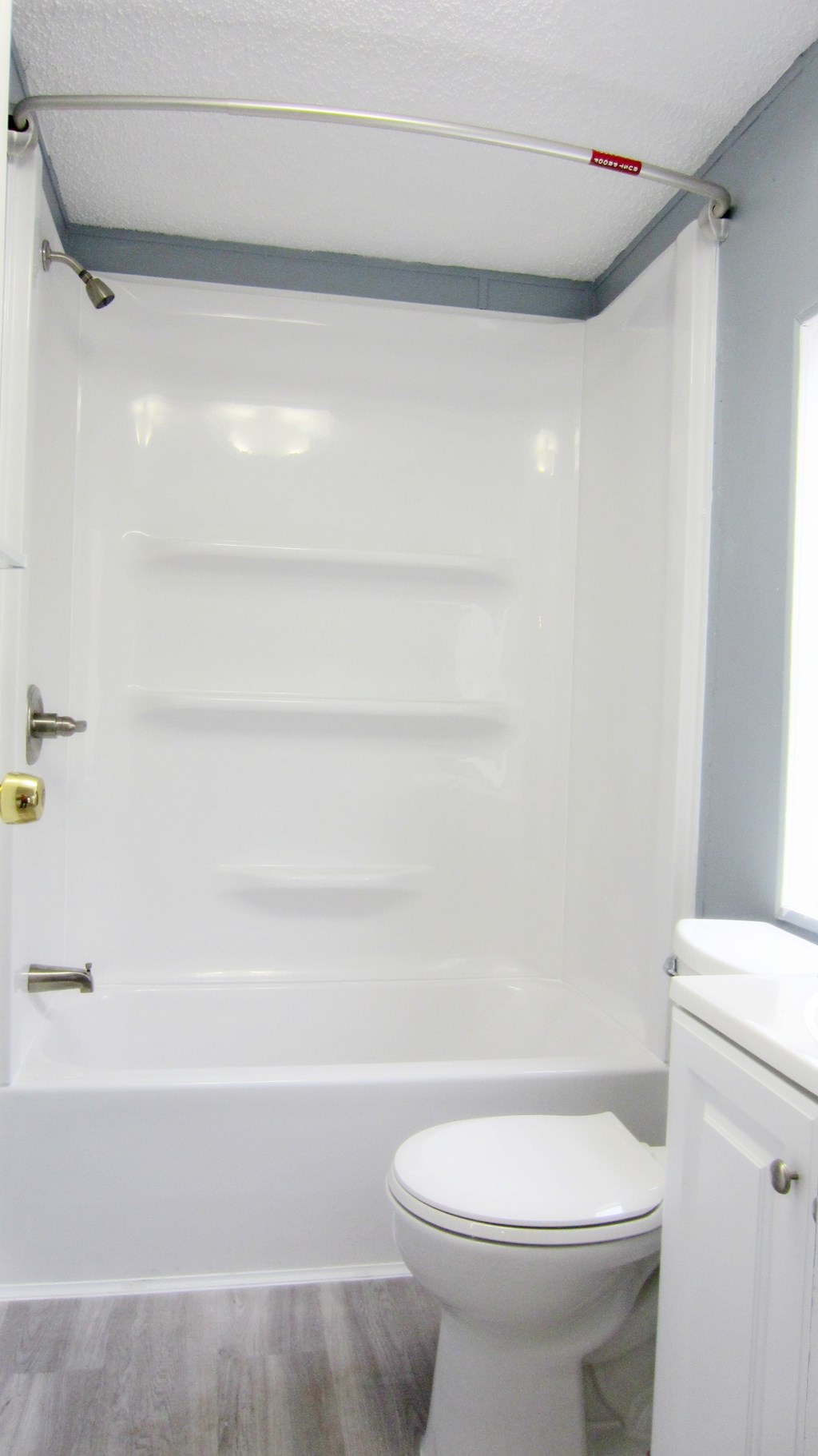 A white toilet in a small bathroom with a walk-in shower.