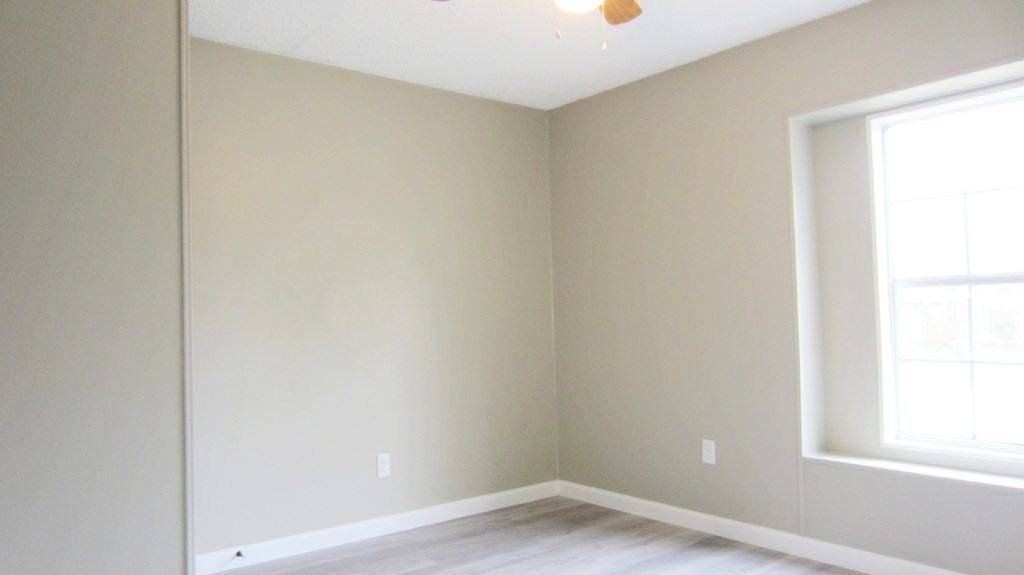 A room with a window and a ceiling fan.