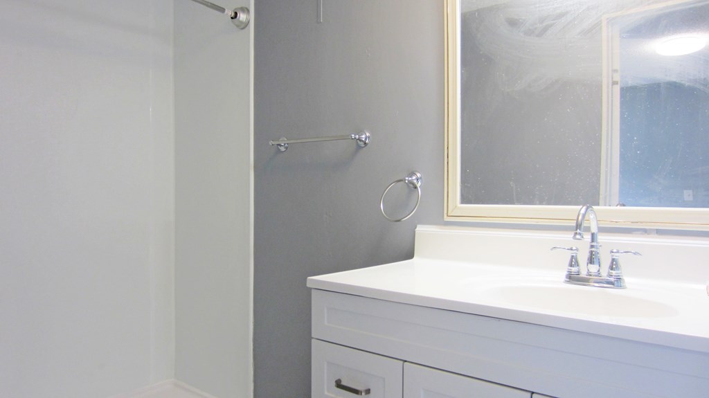 A white bathroom sink with a mirror above it.