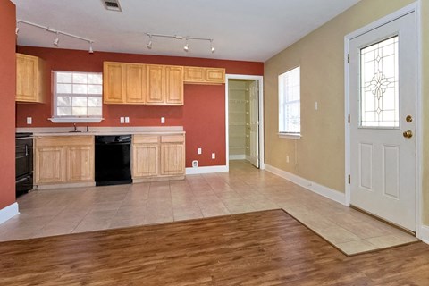 A kitchen with wooden cabinets and a black dishwasher.