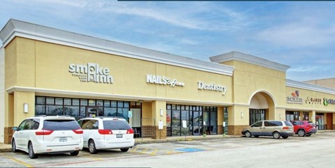 the front of a shopping mall with cars parked outside