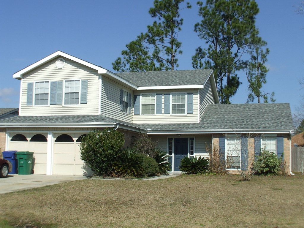 A house with a grey roof and white garage doors.