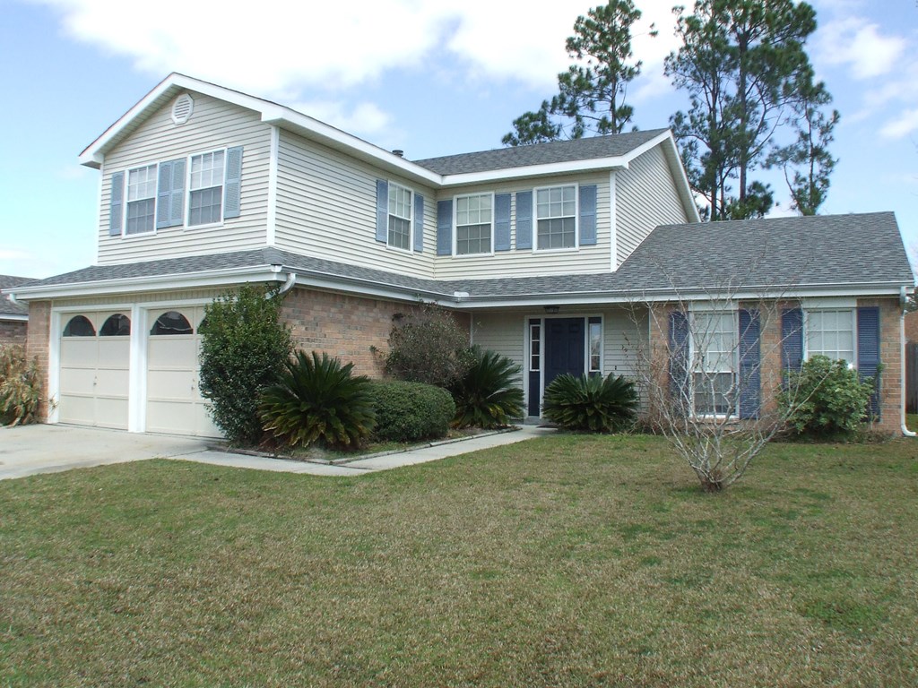 A house with a grey roof and a white garage door.