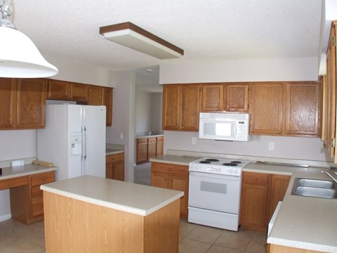 A kitchen with wooden cabinets and white appliances.