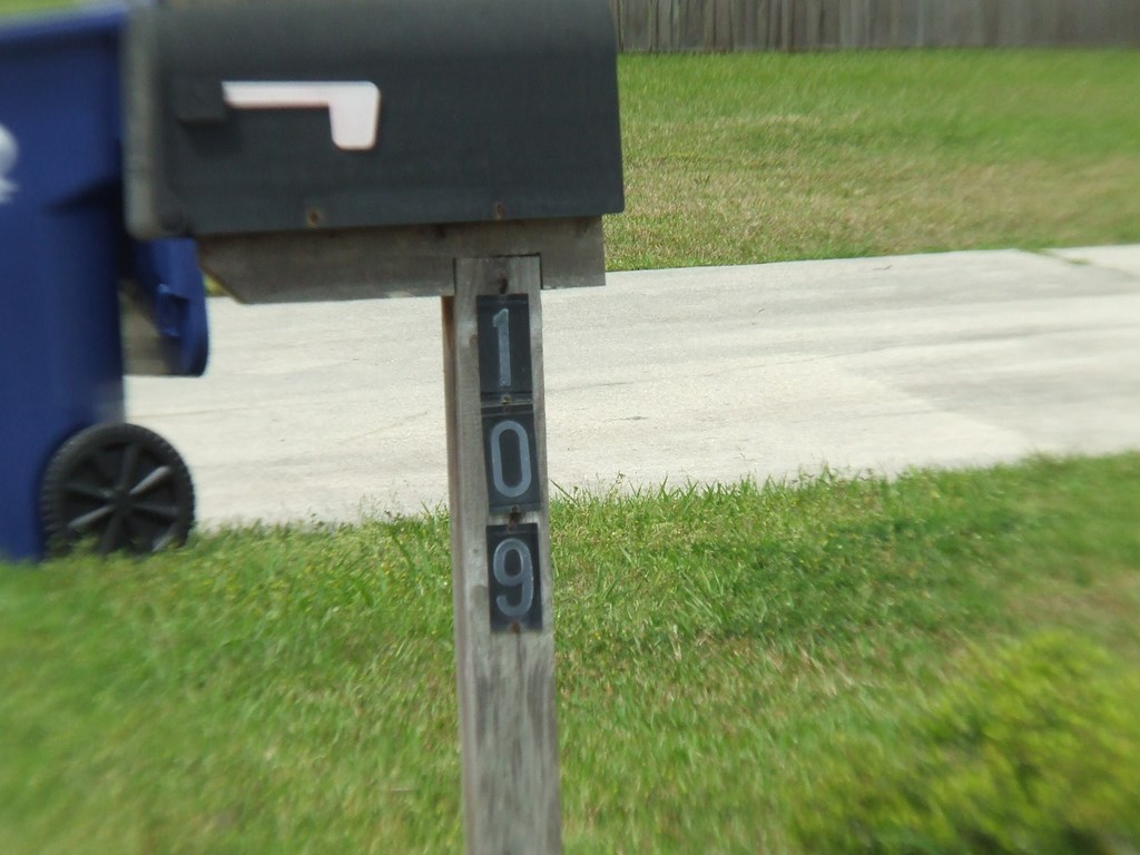 A mailbox with the number 109 on a wooden post.