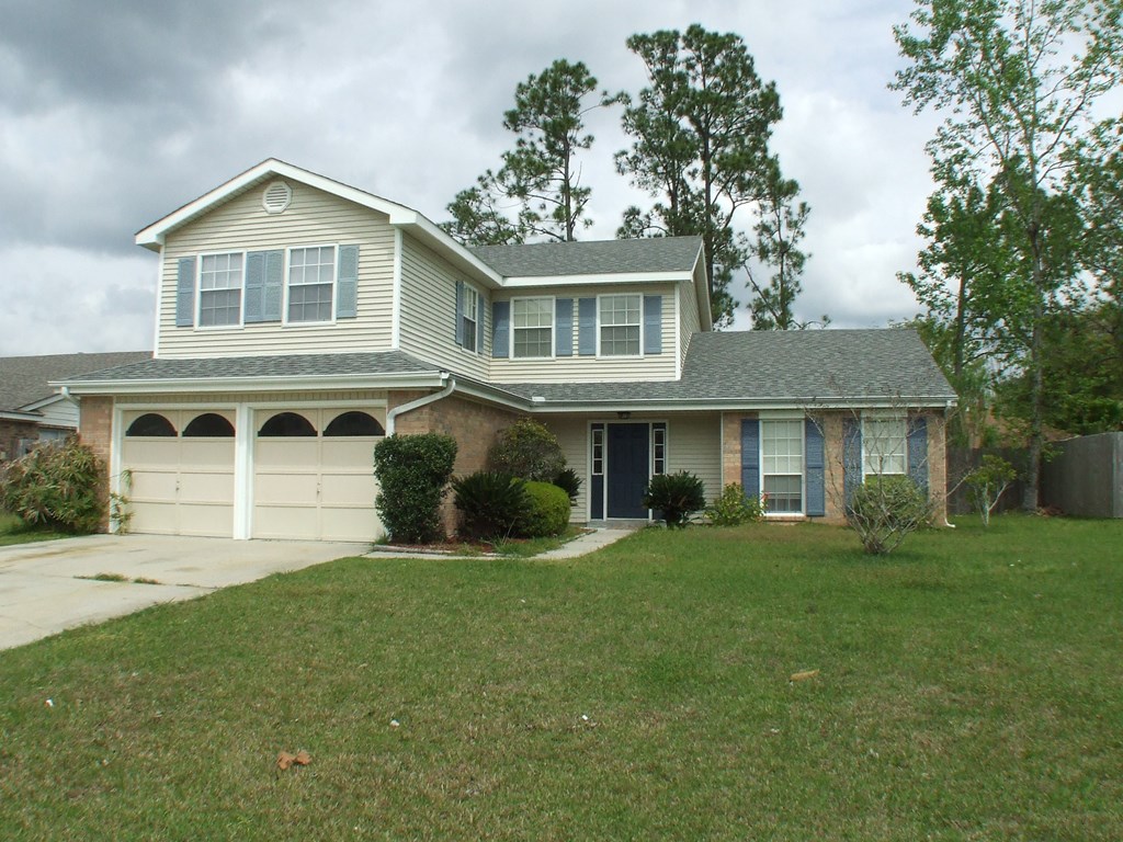 A house with a grey roof and a white garage door.