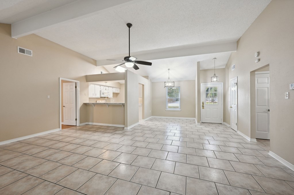 A spacious room with a ceiling fan and tile flooring.