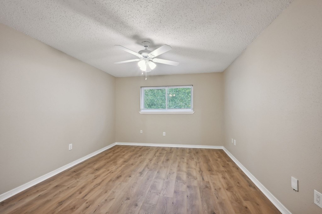 A room with a ceiling fan and a window.
