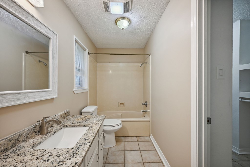 A bathroom with a sink, toilet, and bathtub.