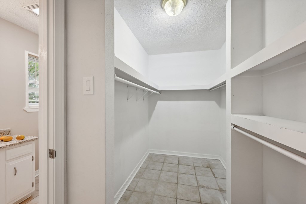 A white kitchen with a tiled floor and a white ceiling.