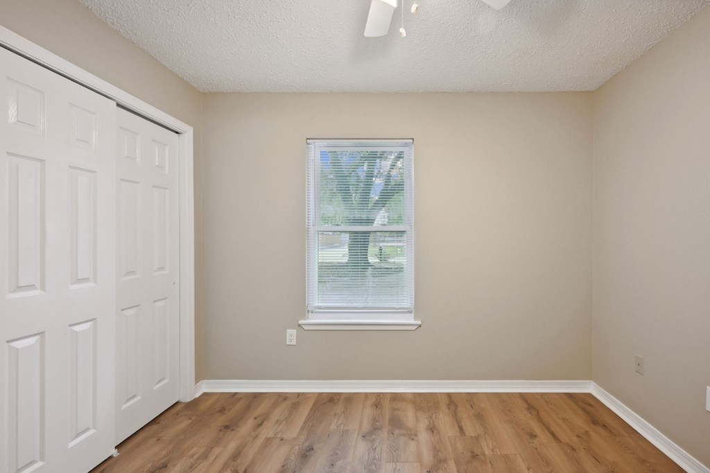 A room with a white door and a window with blinds.