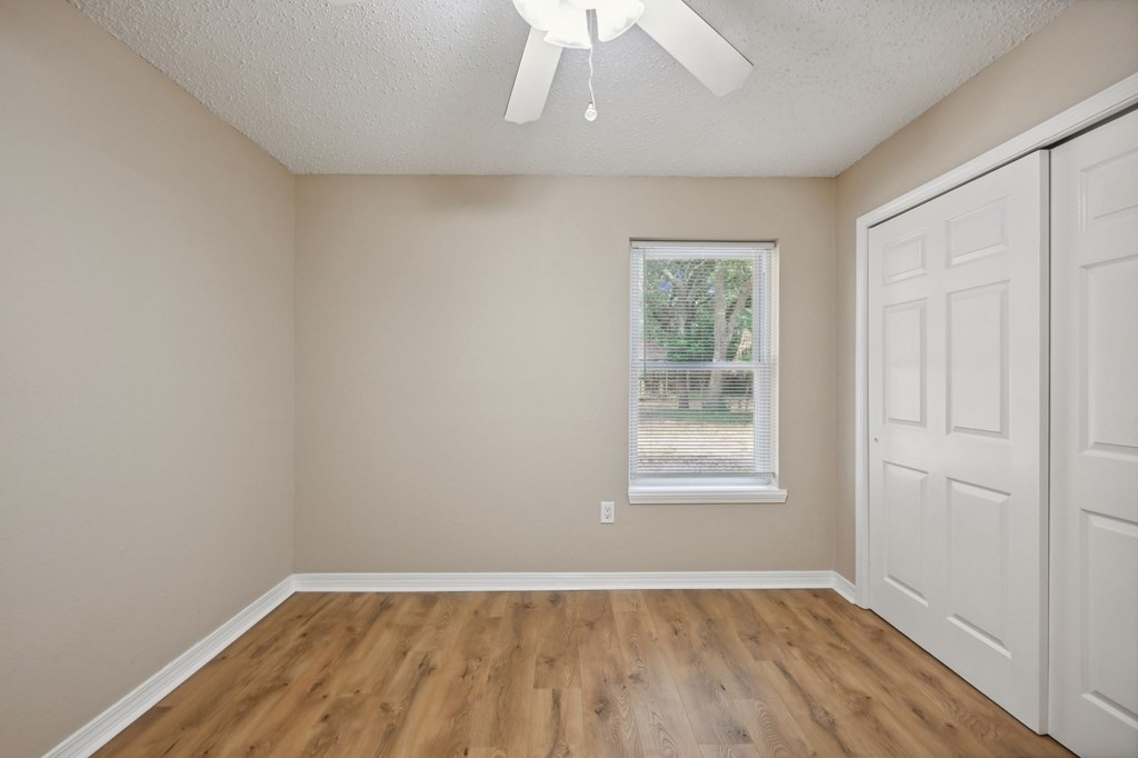 A room with a window and a ceiling fan.