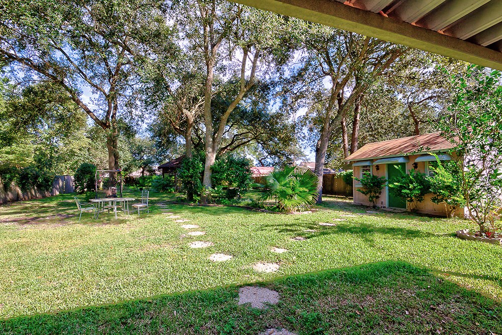 A backyard with a picnic table and a house.