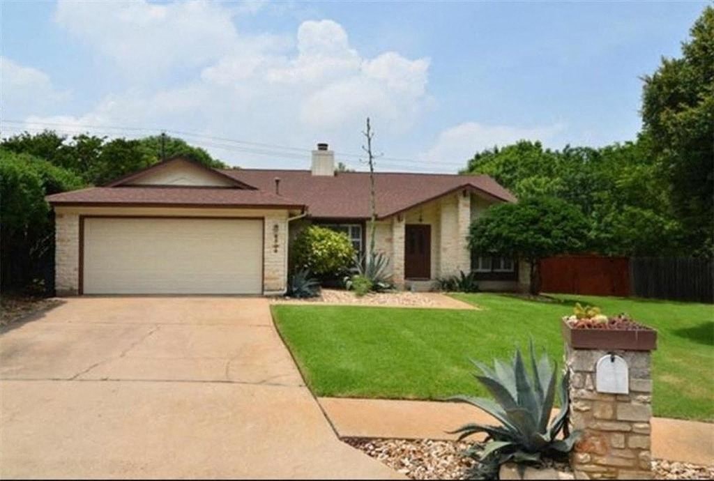 a house with a driveway and a lawn