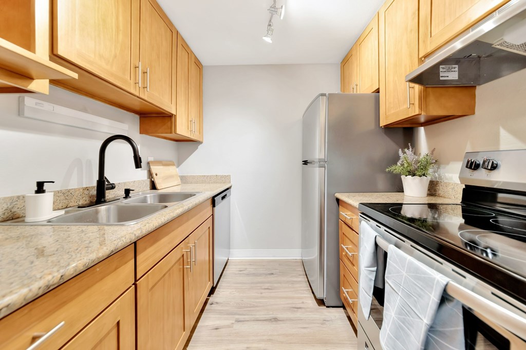 a kitchen with wooden cabinets and stainless steel appliances