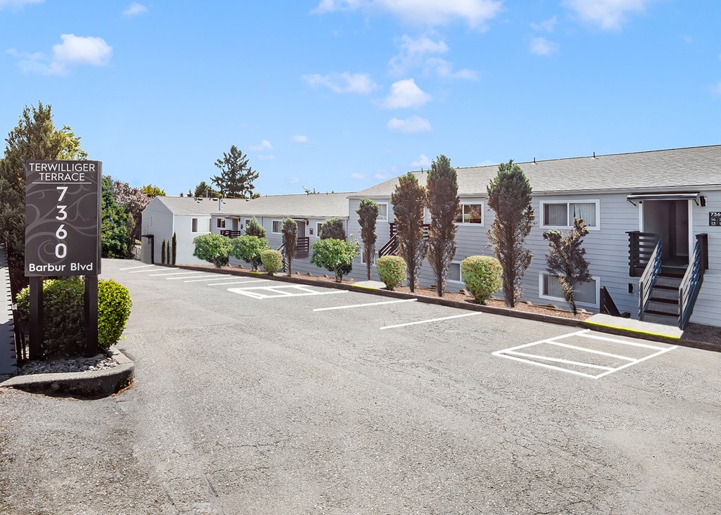 A parking lot with a sign that says "TERRALLEGGER TERRACE 7360 Barbur Blvd".