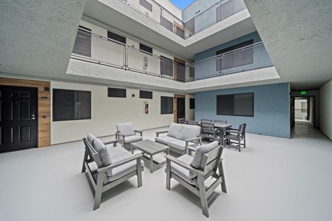 A modern living room with a glass ceiling and a large table and chairs.