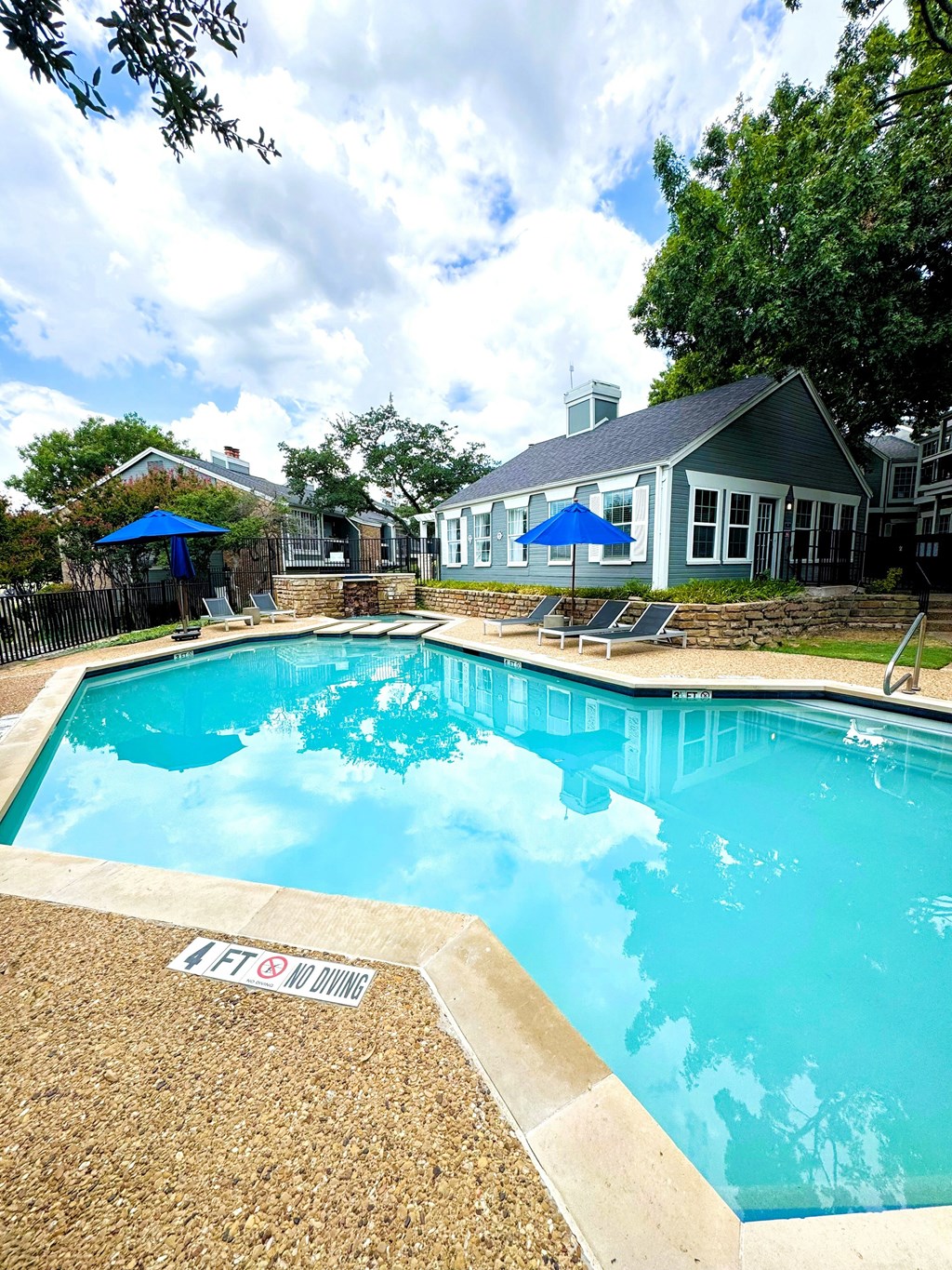 A pool with a blue sky and clouds in the background.