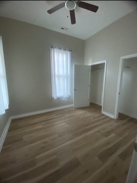 a living room with wooden floors and a ceiling fan