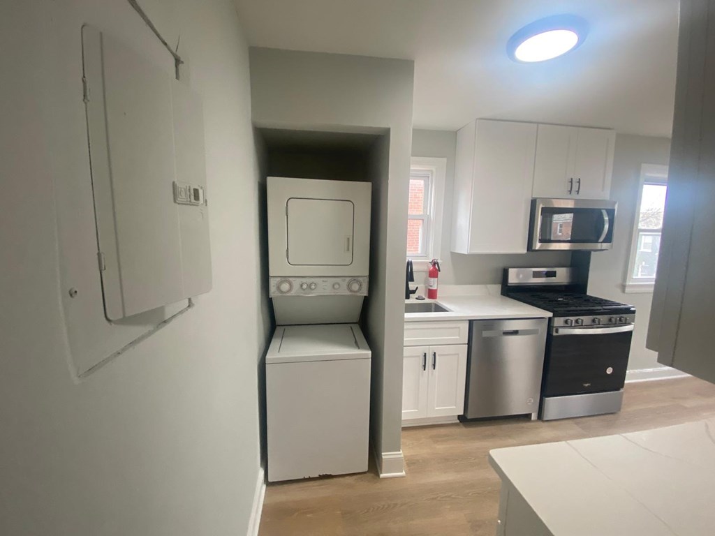 A small kitchen with a washing machine and a microwave.