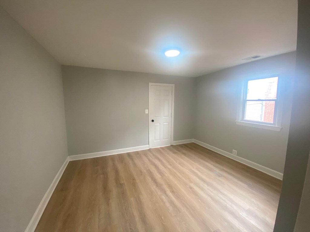 A room with a wooden floor and a white door.