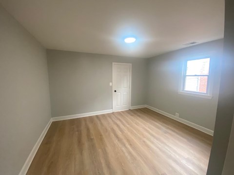 A room with a wooden floor and a white door.