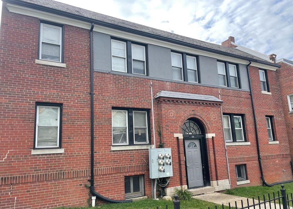 A red brick building with a black door and windows.