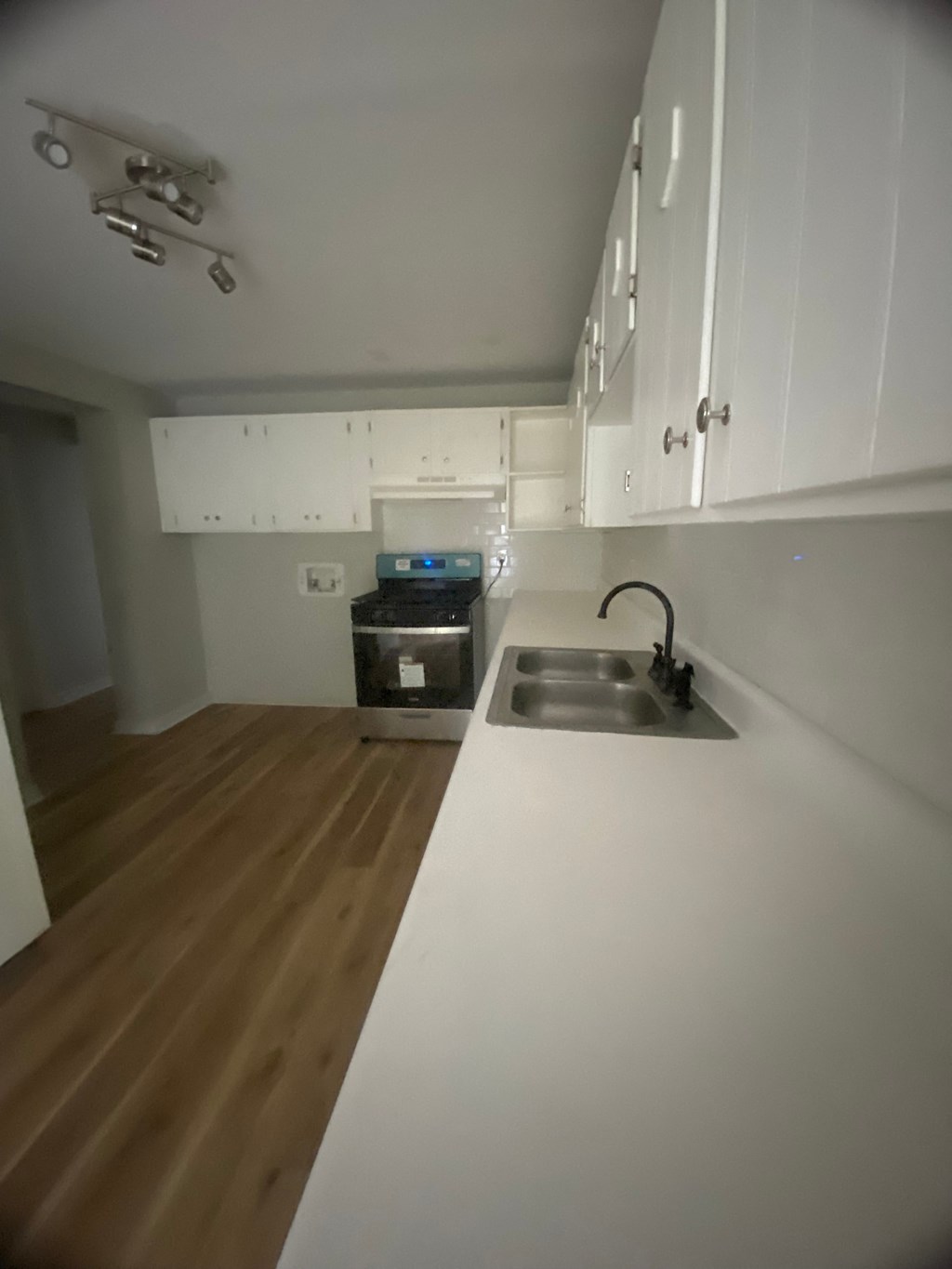 an empty kitchen with white cabinets and a sink