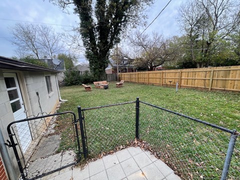 a backyard with a fence and a yard and a house