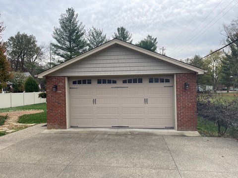 a garage with a white door and a driveway