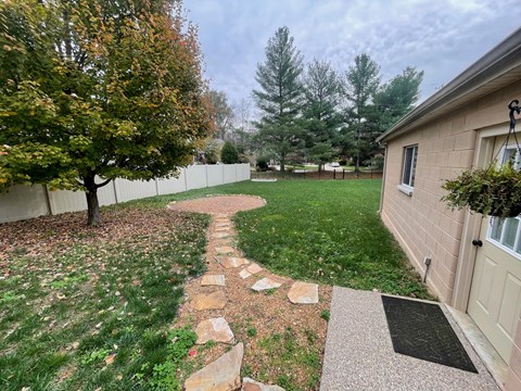 a backyard with a path leading to a house