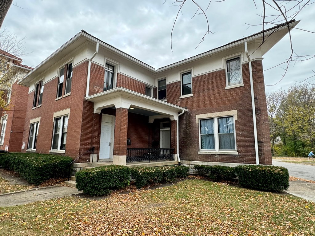 a brick building with a lawn in front of it
