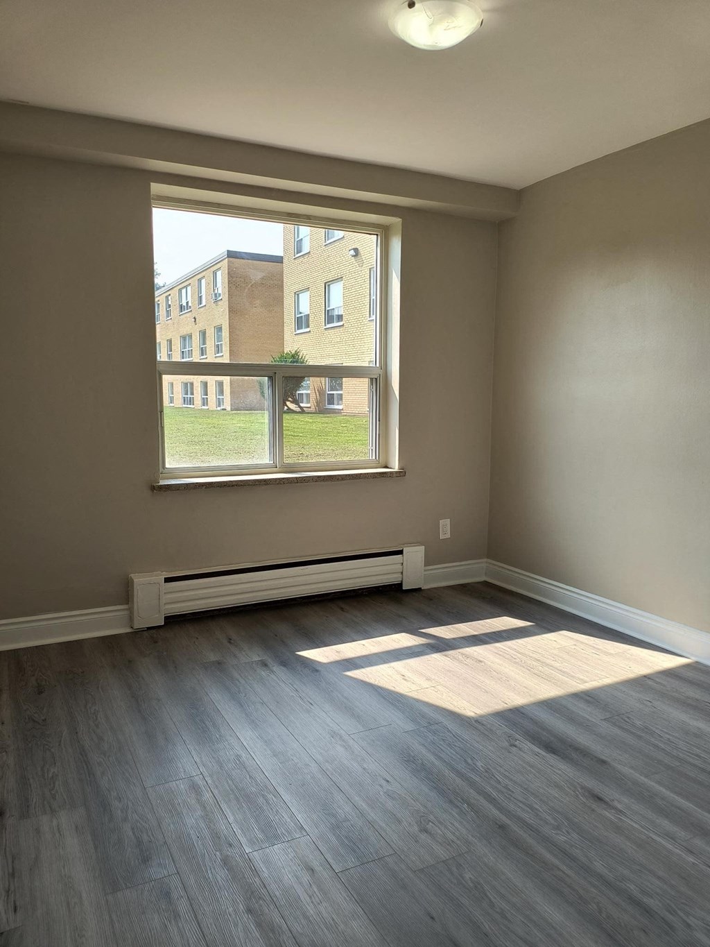 A room with a window and a radiator on the wall.