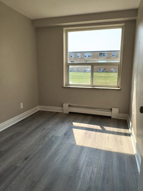 A room with a large window and a bench.