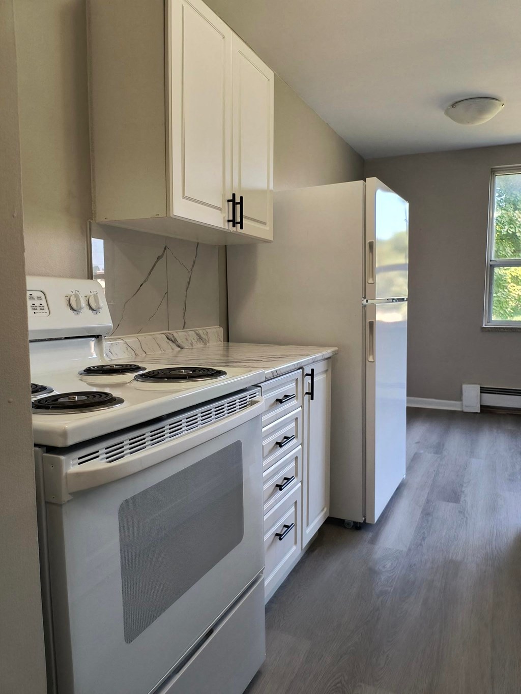 A kitchen with a white stove and cabinets.