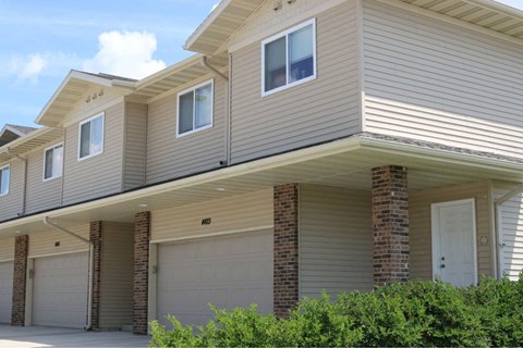 A beige house with a white door and windows.
