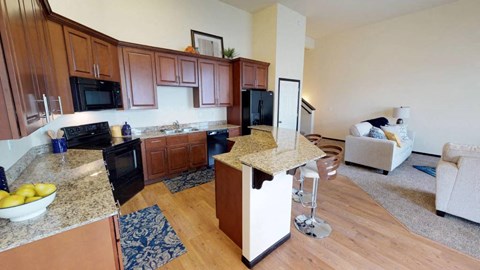A kitchen with wooden cabinets and a black refrigerator.