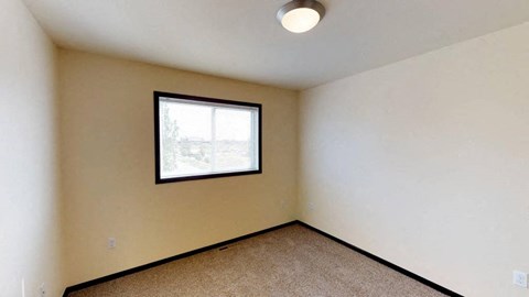 A room with a window and carpeted floor.