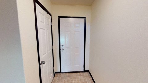 A white door is in the middle of a hallway.